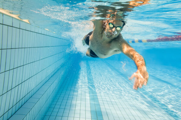 Technikkurs Mann krault durch Schwimmbecken